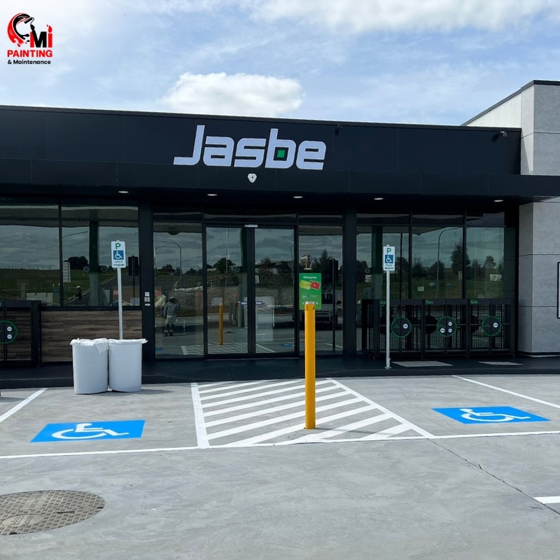 New paint commercial building named Jasbe with a parking lot in front with a prominent sign.