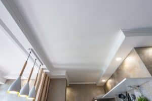 White kitchen ceiling with three hanging pendant lights. Waterproof gyprock is a moisture-resistant plasterboard that can be used in kitchens to create a durable and long-lasting ceiling.