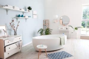 Modern bathroom interior with bathtub, mirror, vanity with drawers, houseplants and a rug. Waterproof gyprock is a moisture-resistant plasterboard suitable for use in bathrooms due to its ability to withstand humidity.
