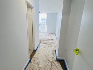 Hallway prepared for plastering internal walls with protective sheets.