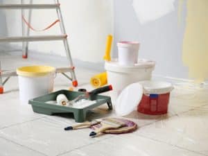 Painting tools and supplies on the floor, showing how improper materials can make paint smell bad.