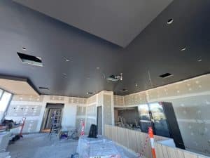 Construction site ceiling with gyprock patches and lighting holes - when to patch gyprock professionally.