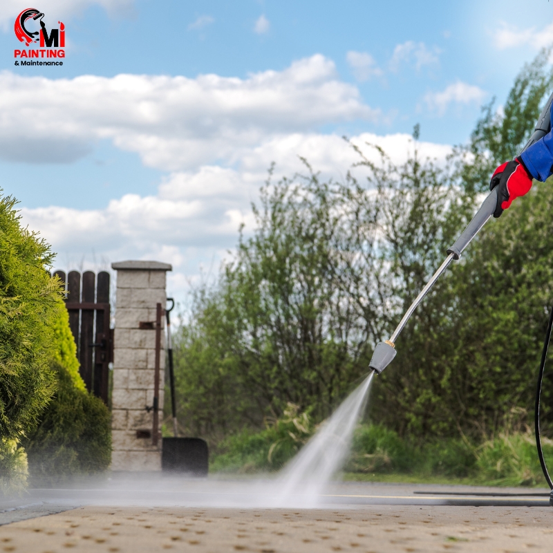 Professional driveway pressure cleaning in Sydney, showing a worker using a high-pressure washer on an outdoor driveway area.