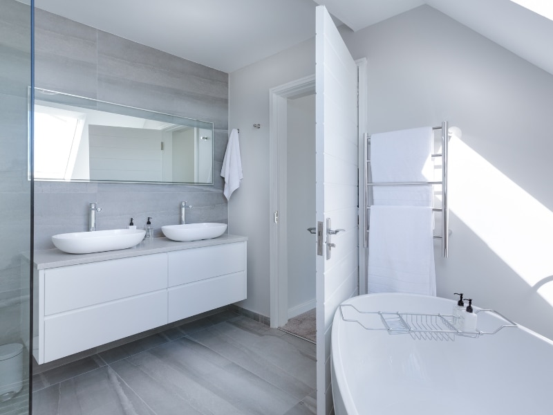 Bright contemporary bathroom with double sinks and natural light after bathroom painting.