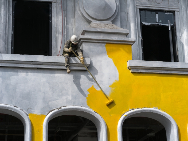 commercial building paint in progress on classic façade with roller