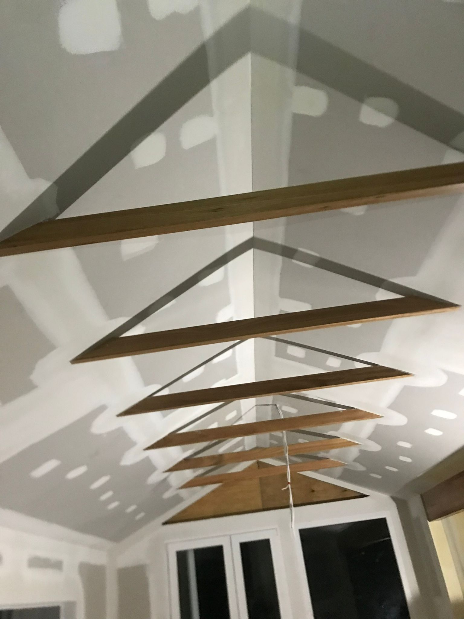 Raked ceiling plastering with feature timber battens during interior fit-out